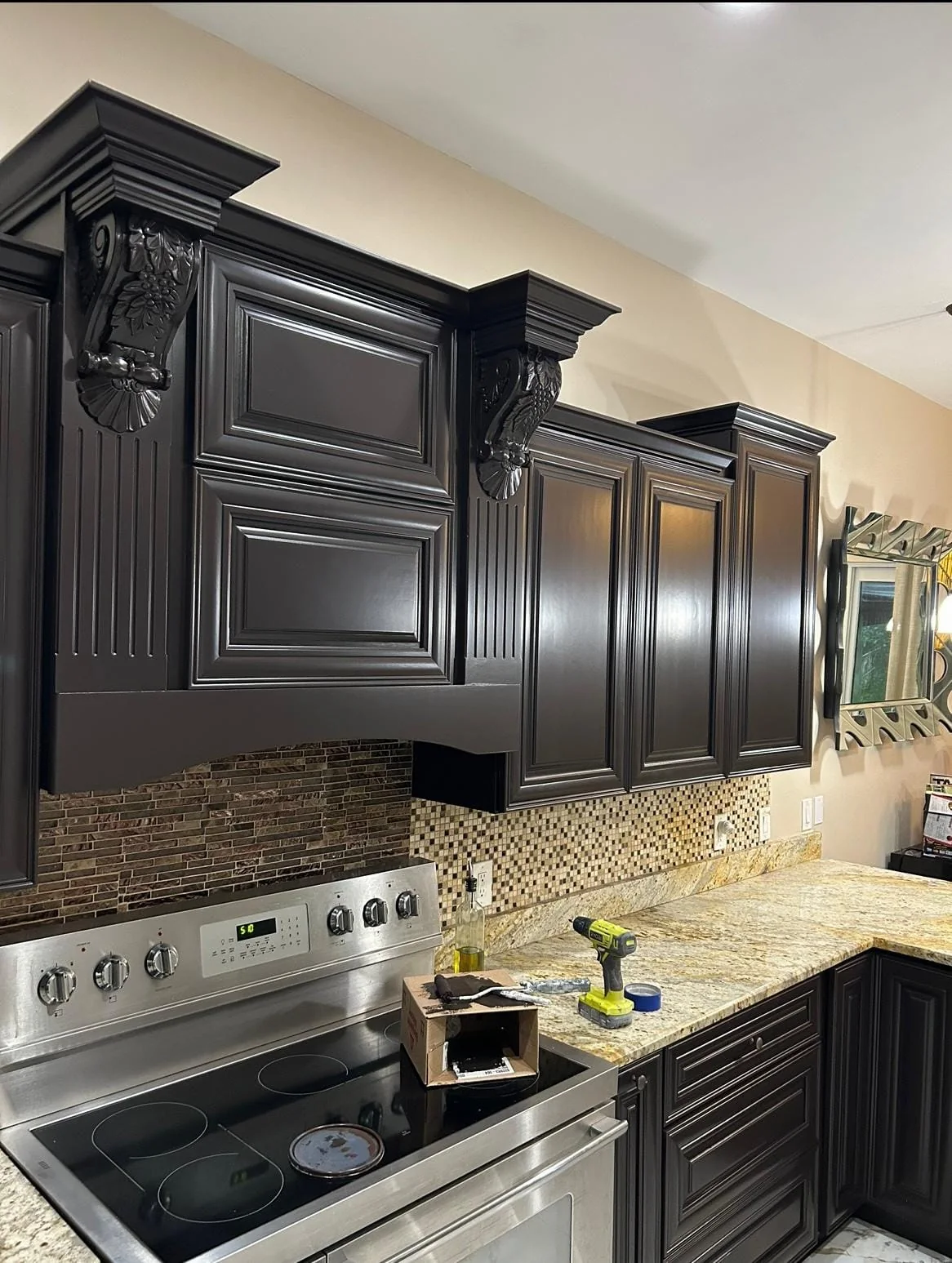 Espresso-brown kitchen cabinets with carved corbels, refinished by Gashi Painting