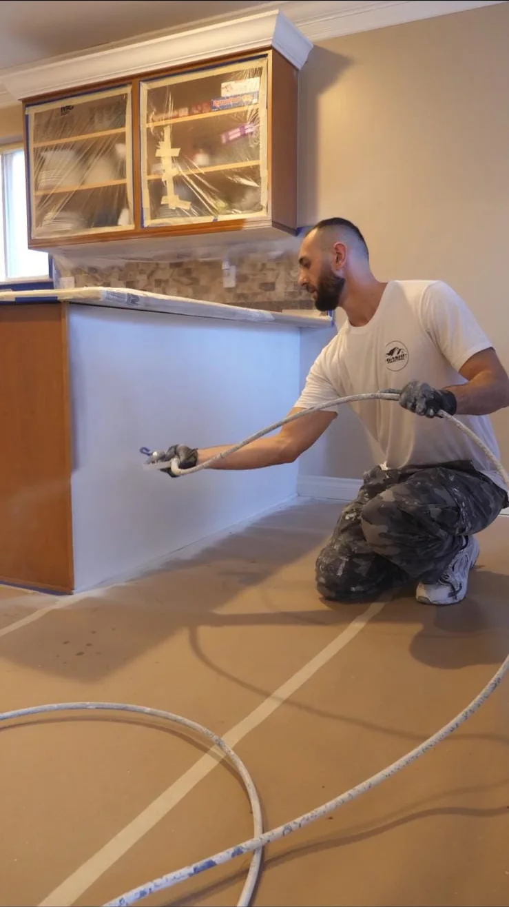 Gashi Painting painter spray-finishing a kitchen island