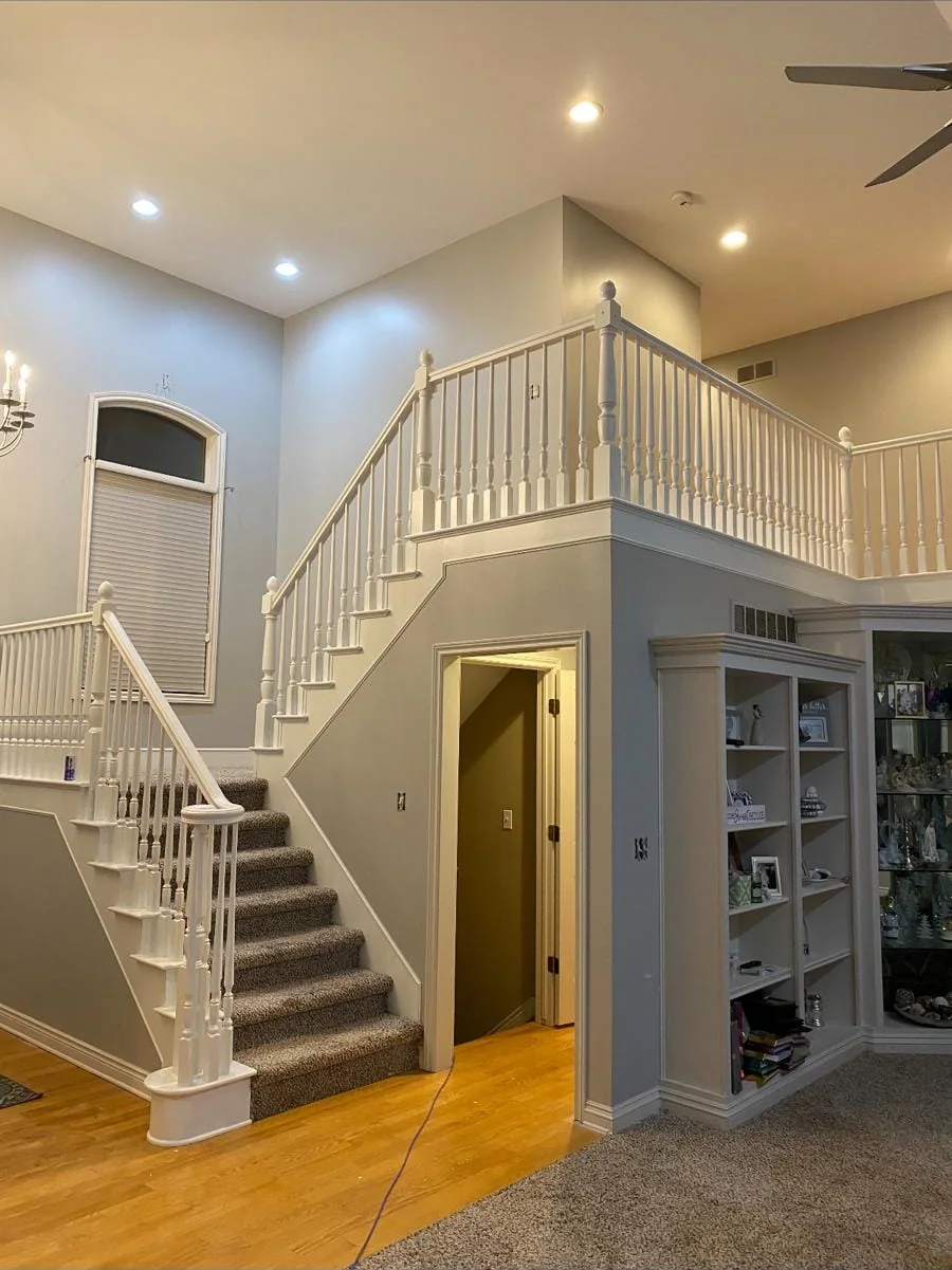 Two-story living room with freshly painted walls, trim and stair railings