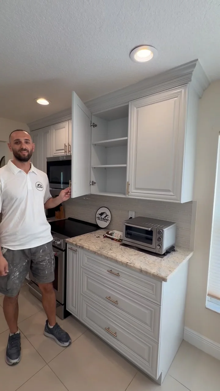 Gashi Painting team member beside refinished cabinets